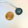 brain pendant next to penny to show smaller size