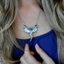 flying lady necklace being worn to show scale