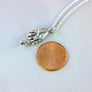 hand necklace next to penny for size comparison