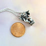 gargoyle pendant next to penny for scale