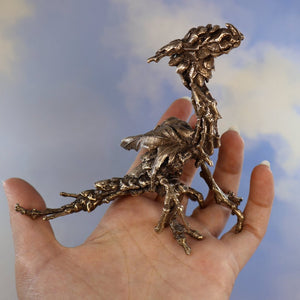 bronze dragon sitting in palm of hand