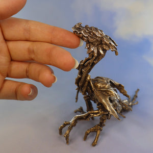 highly detailed bronze dragon sculpture shown with hand for scale