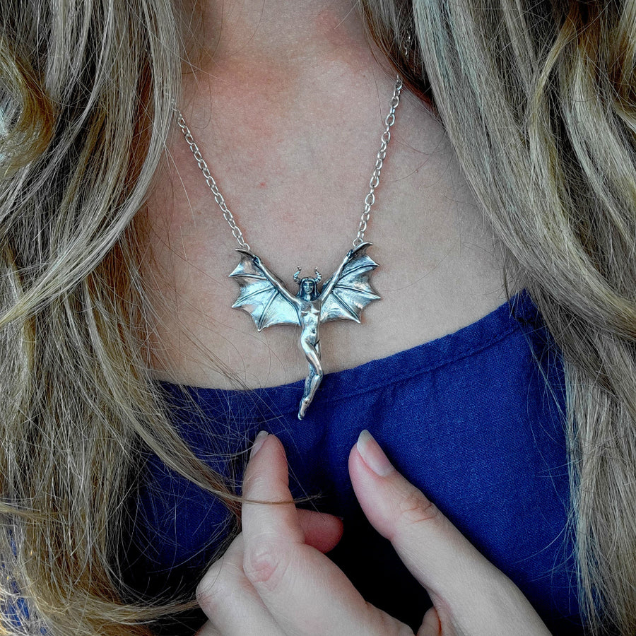 flying lady necklace being worn to show scale