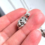 side profile of lion charm showing chain going through built-in bail